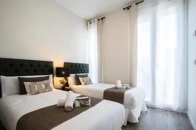 two beds in a room with white walls and windows at MD Jorda Roig Arena in Valencia