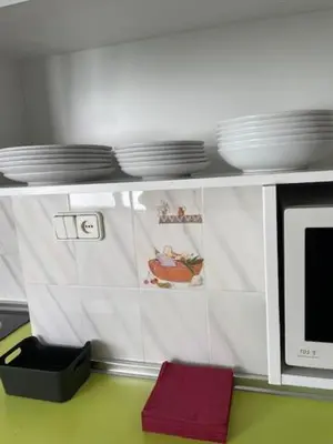 a kitchen with a microwave and plates on a shelf at Tranquila y Céntrica Habitación Matrimonio en Vivienda Compartida in Valencia