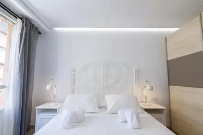 a white bedroom with two white towels on a bed at GuestReady - El Cabanyal stay near the beach in Valencia