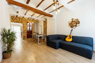 a living room with a blue couch and a guitar at Mini apartamento en casa rural in Quesa