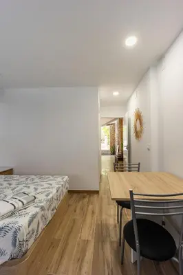 a bedroom with a bed and a wooden table at Mini apartamento en casa rural in Quesa