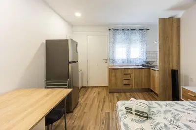 a kitchen with a refrigerator and a table in a room at Mini apartamento en casa rural in Quesa
