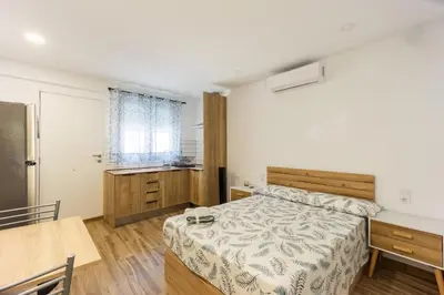 a bedroom with a bed and a table and a kitchen at Mini apartamento en casa rural in Quesa