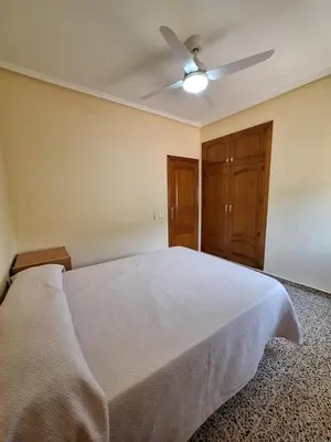 a bedroom with a white bed with a ceiling fan at Villa cerca de Valencia con piscina junto a la montaña in Vilamarxant