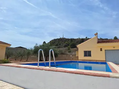 a swimming pool in front of a house at Villa cerca de Valencia con piscina junto a la montaña in Vilamarxant