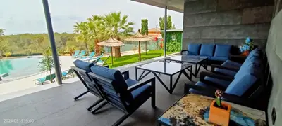 a patio with blue chairs and a table and a pool at The Blue Diamond Villa-25min to Valencia in Turís