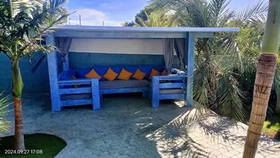 a blue bench with orange pillows on a patio at The Blue Diamond Villa-25min to Valencia in Turís