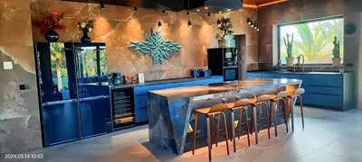 a kitchen with blue cabinets and a bar with stools at The Blue Diamond Villa-25min to Valencia in Turís