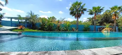 a swimming pool with blue water and palm trees at The Blue Diamond Villa-25min to Valencia in Turís