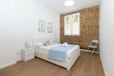 a bedroom with a bed and a brick wall at GuestReady - Lovely flat by Valencia University in Valencia