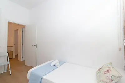 a bedroom with a white bed with a blue blanket at GuestReady - Lovely flat by Valencia University in Valencia