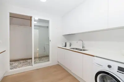 a white kitchen with a sink and a washing machine at GuestReady - Lovely flat by Valencia University in Valencia