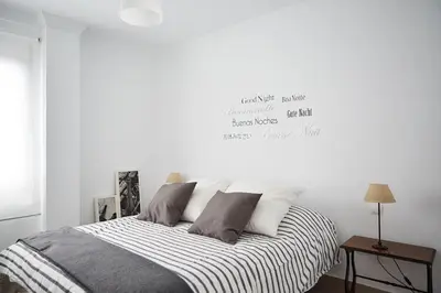 a bedroom with a bed with a white wall at Amplio y cómodo apartamento en el centro in Valencia