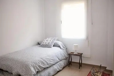 a white bedroom with a bed and a window at Amplio y cómodo apartamento en el centro in Valencia