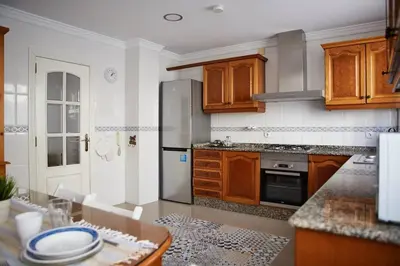a kitchen with wooden cabinets and a stainless steel refrigerator at Amplio y cómodo apartamento en el centro in Valencia
