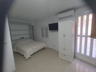 a bedroom with a bed and a cabinet and a window at Estudio cerca de Oceanogràfic Valencia in Valencia