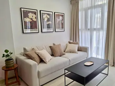 a living room with a white couch and a table at Bonito apartamento de 2 habitaciones cerca de la Estación Joaquín Sorolla in Valencia