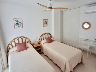 two beds in a room with a ceiling fan at Bonito apartamento de 2 habitaciones cerca de la Estación Joaquín Sorolla in Valencia