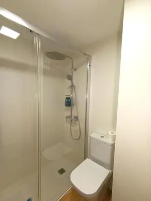 a bathroom with a toilet and a glass shower at Play-Puig Beach Flat in El Puig