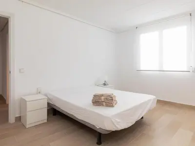 a white room with a bed and a window at Montolivet Gulliver in Valencia