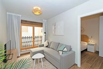 a living room with a couch and a bedroom at Maritime Apartamentos Puerto in Valencia