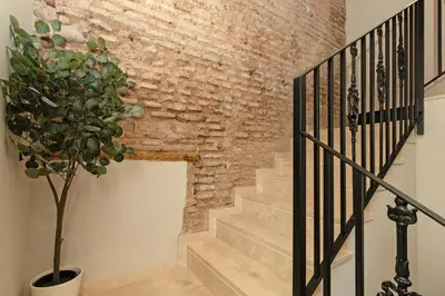a brick wall and stairs with a potted plant at Maritime Apartamentos Puerto in Valencia