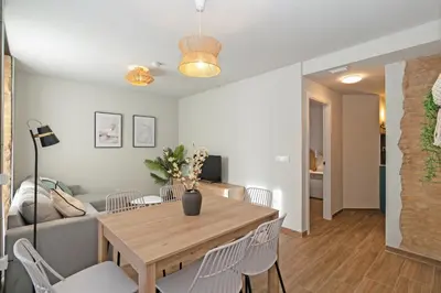 a dining room and living room with a table and chairs at Maritime Apartamentos Puerto in Valencia