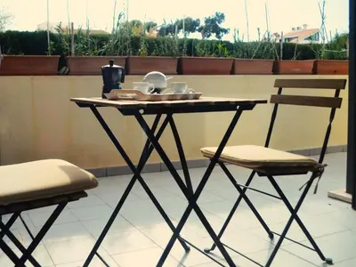 a table with a tray of dishes and two chairs at Apartamento a 60 metros de la Playa in Playa de Mar