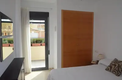 a bedroom with a bed and a door to a balcony at Apartamento a 60 metros de la Playa in Playa de Mar