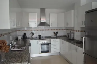 a kitchen with white cabinets and a stainless steel appliance at Apartamento a 60 metros de la Playa in Playa de Mar