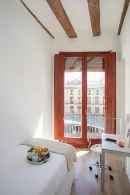 a white room with a bed and a large window at SingularStays Plaza Redonda II in Valencia