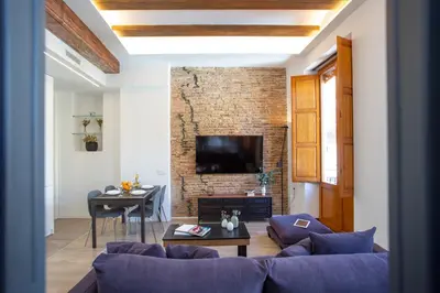 a living room with a couch and a brick wall at SingularStays Plaza Redonda II in Valencia