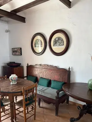 a living room with two tables and a bench and two mirrors at Casa Rural Huerto del Carmen in Puebla Larga