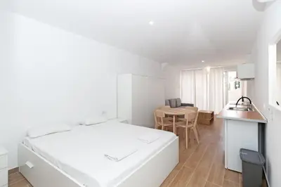 a white bedroom with a bed and a table at GuestReady - Retiro agradable en Valencia in Valencia