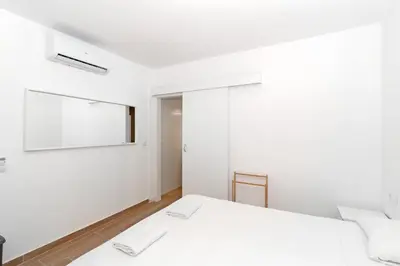 a white bedroom with two beds and a window at GuestReady - Retiro agradable en Valencia in Valencia