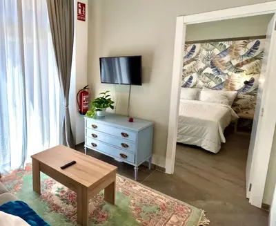 a living room with a bed and a mirror at Elegante y nuevo in Valencia