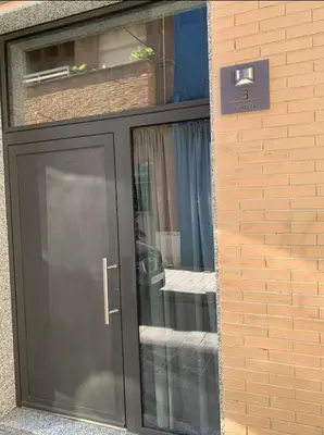 a black door with a sign on the side of a building at Céntrico, coqueto y vintage in Valencia