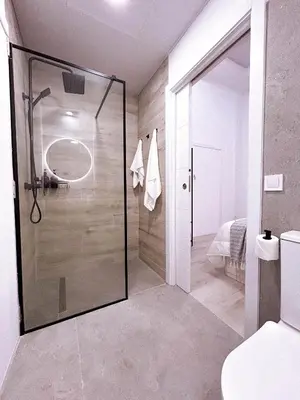 a bathroom with a shower with a glass door at La Brisa Lofts in Valencia
