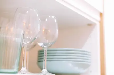 three wine glasses sitting on a table with a stack of plates at La Brisa Lofts in Valencia