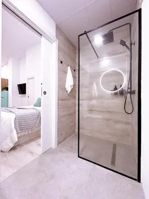 a glass shower in a bedroom with a bed at La Brisa Lofts in Valencia