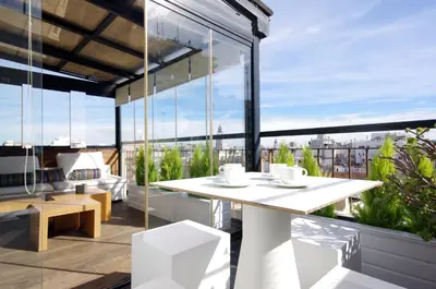 a balcony with a table and chairs and large windows at Vivaldi Penthouse Ayuntamiento in Valencia