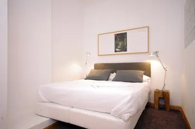 a bedroom with a white bed with a white bed frame at Vivaldi Penthouse Ayuntamiento in Valencia