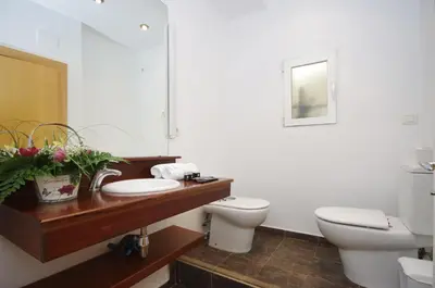 a white bathroom with a toilet and a sink at Vivaldi Penthouse Ayuntamiento in Valencia