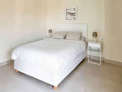 a white bed in a white bedroom with a night stand at Non Stress Seven Up in Valencia