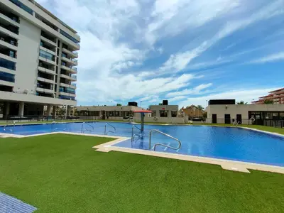 a large swimming pool with green grass next to a building at Non Stress Seven Up in Valencia