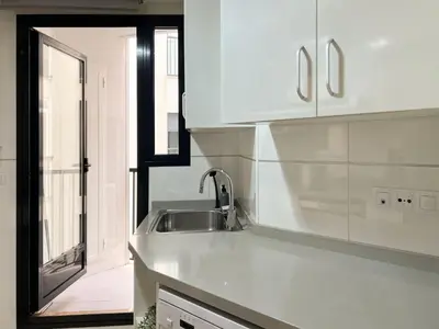 a white kitchen with a sink and a window at Non Stress Seven Up in Valencia