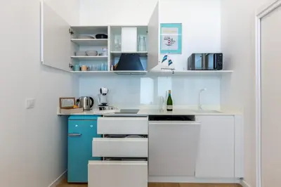 a kitchen with white cabinets and blue appliances at Estudio Marina Ivana in Valencia
