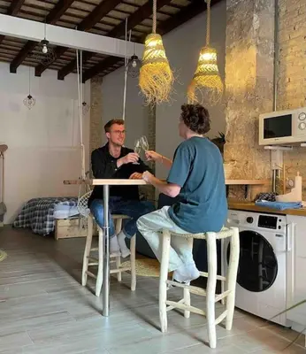 a man and woman sitting at a table in a kitchen at Ruzafa experience Oceanografic ciencias in Valencia