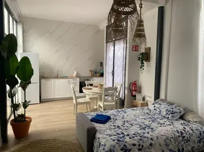 a bedroom with a bed and a kitchen with a table at Apto ruzafa patio center science oceanografic in Valencia