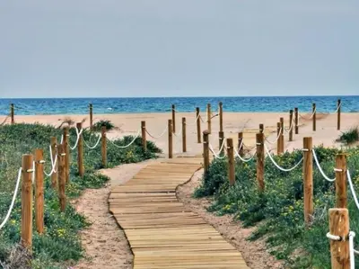 a wooden path leading to the beach at Loft Temporal a 2 min de Playa de Sagunto A1 in Puerto de Sagunto